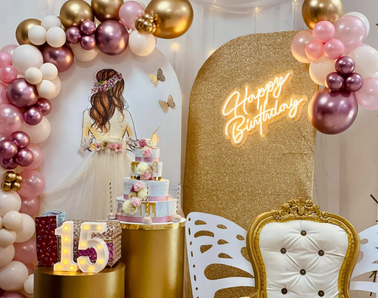 Montaje de celebración con fondo dorado iluminado, globos y torta de varios pisos